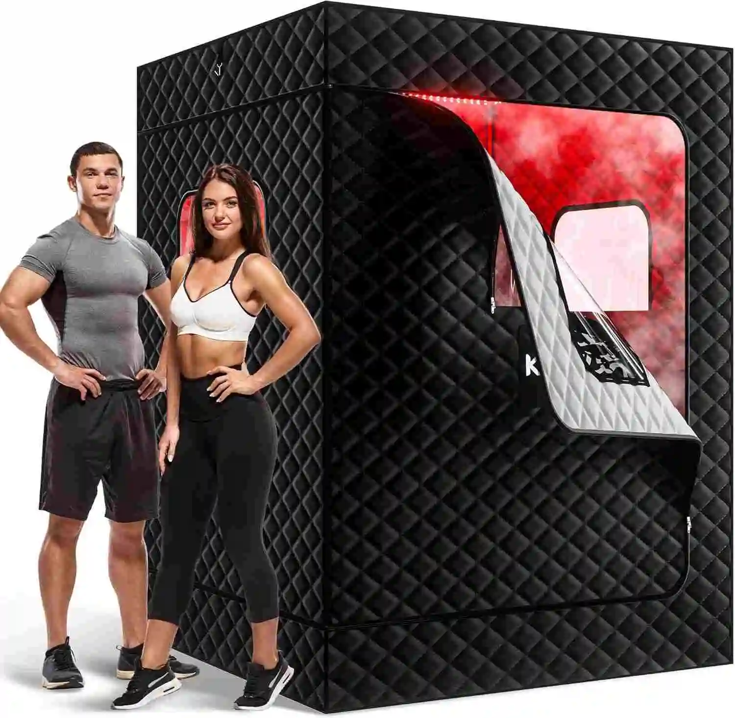 A man and a woman in athletic wear stand confidently beside a large black quilted sauna tent. The tent is partially open, revealing red lighting inside.