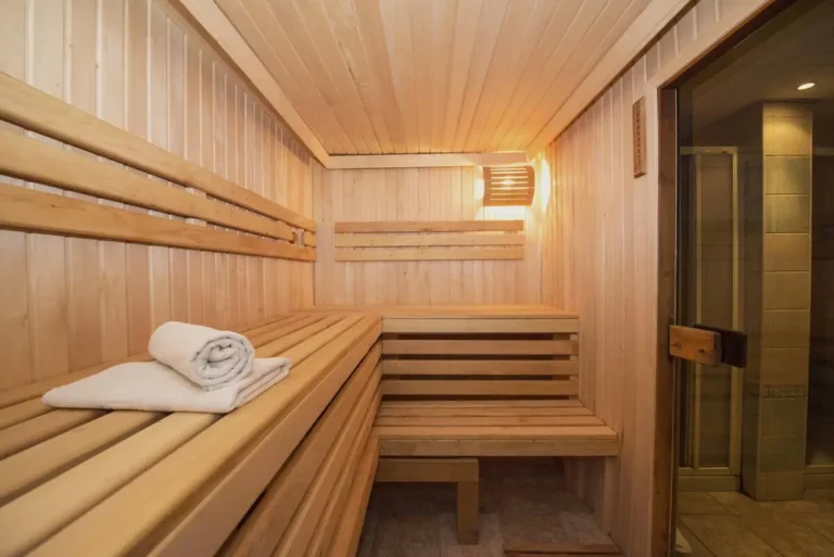 Luxury home sauna with benches and towels; quality materials impact how much a sauna costs.