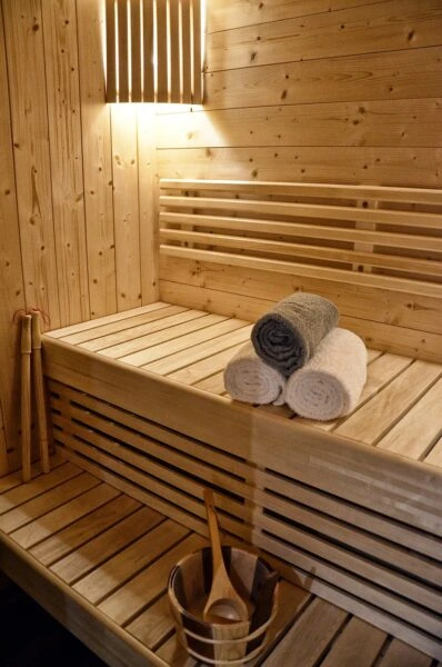 When deciding what to wear in sauna, notice how this beautifully crafted wooden sauna's warm tones and clean lines create a serene space for heat therapy.