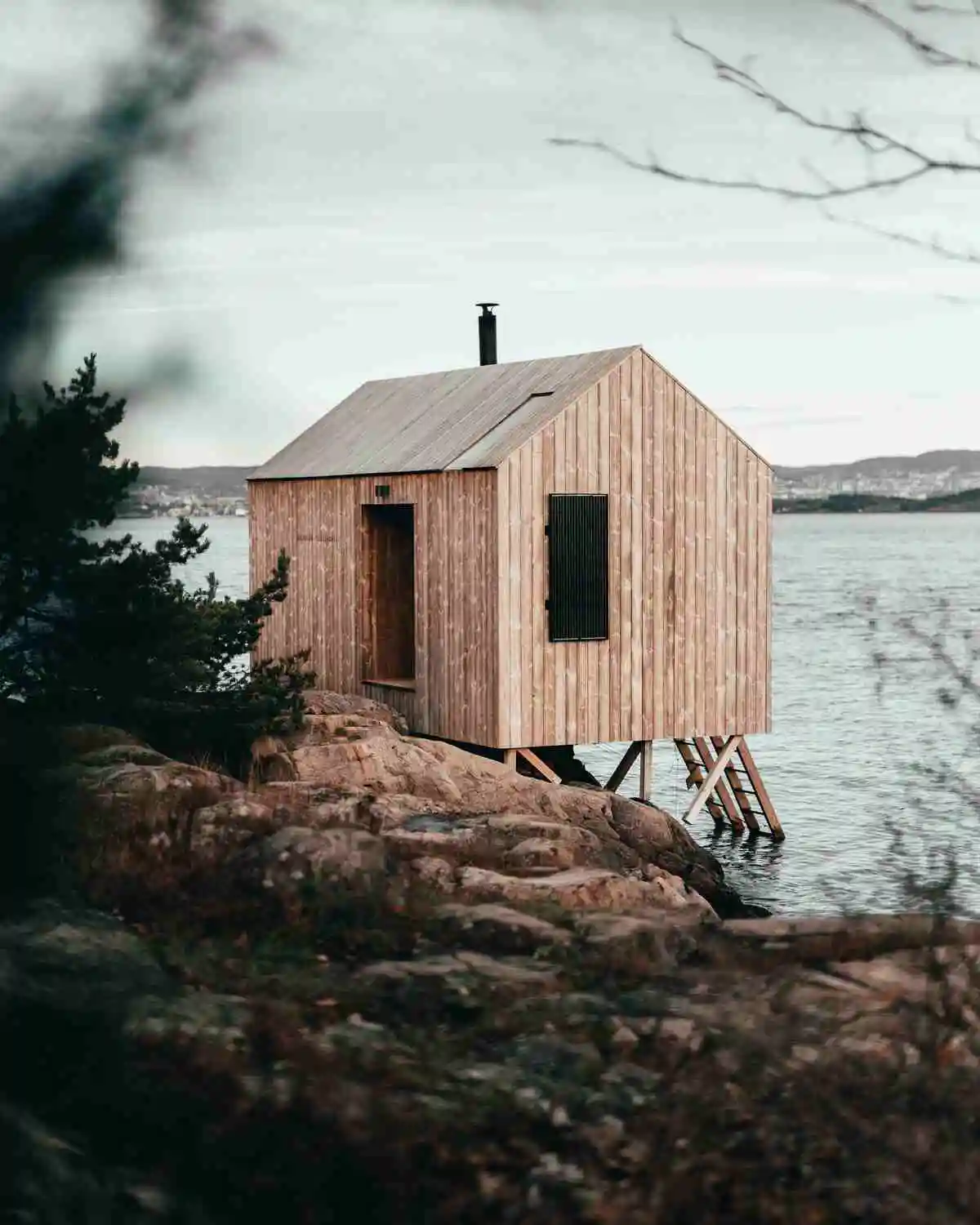 A rustic cabin with a sauna by the ocean shore—explore whether sauna use increases metabolism while enjoying serene waves and blue skies.