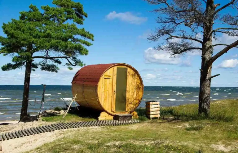 Wooden sauna barrel by the ocean—discover if you should sauna before or after workouts for best results.